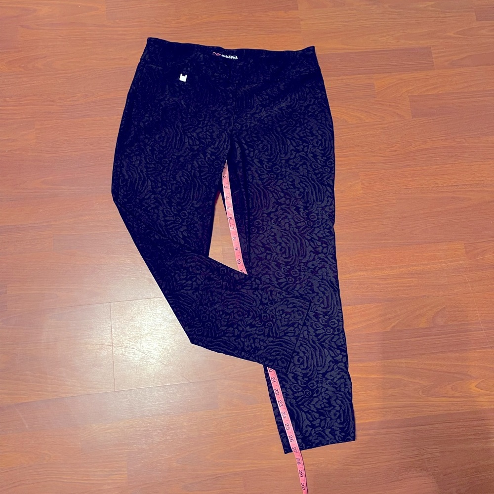 Black pull on ankle pants. Monochromatic rosette pattern print.